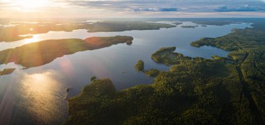Karelia ormanları ile çevrili gün batımında Suoyarvi gölü