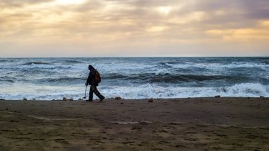 Yaşlı bir adam için hazine aramak için onun metal detektörü kullanır
