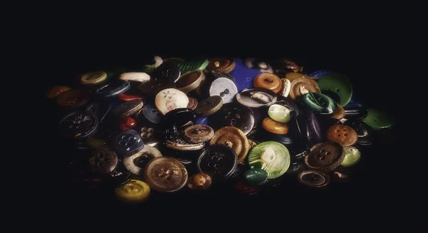 Um monte de botões antigos no fundo preto — Fotografia de Stock