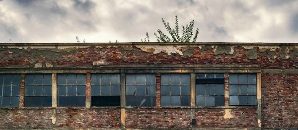 Abandoned factory warehouse with broken windows — Stock Photo, Image