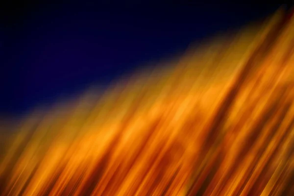 Luz embaçada dourada abstrata com fundo azul escuro — Fotografia de Stock