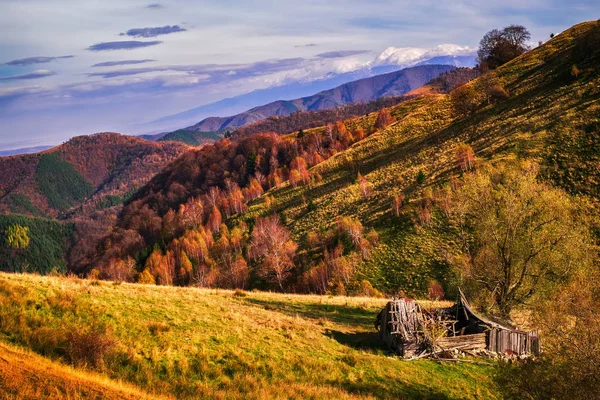 Jesienna scena ze starymi opuszczonych drewnianej stodoły i rumuński Fagaras — Zdjęcie stockowe
