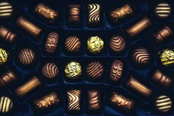 Chocolate candies arranged in the blue box, top close view — Stock Photo, Image