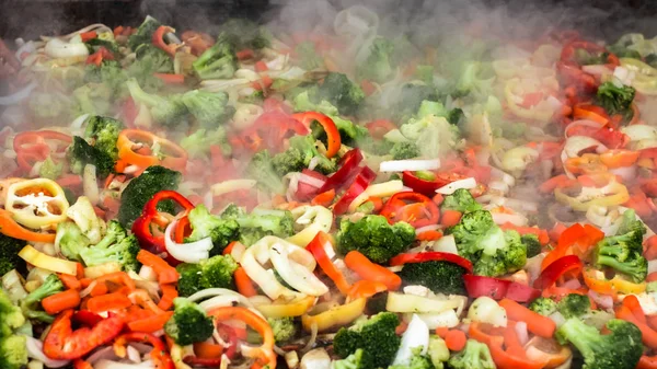 fresh vegetables steaming on iron pan