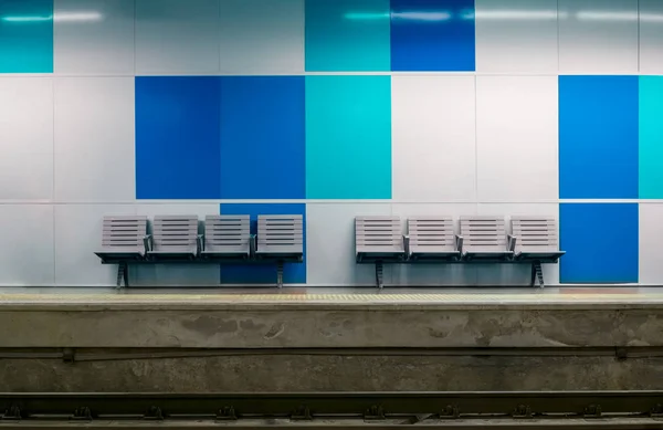 Станция метро с пустыми пластиковыми сиденьями с синими досками в б — стоковое фото