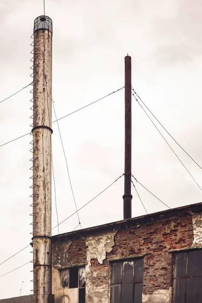 Velhas chaminés industriais abandonadas no céu escuro — Fotografia de Stock