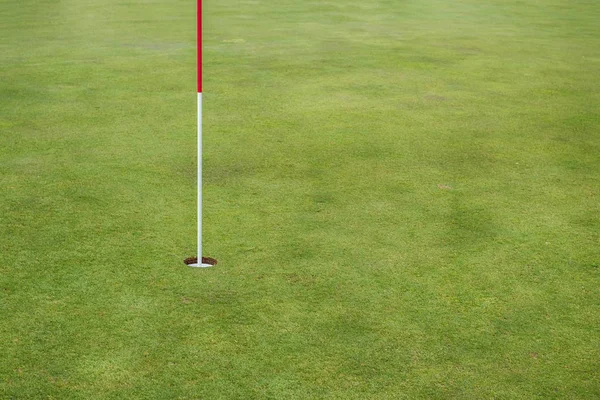 Golf hole on a field in the morning at golf course Royalty Free Stock Images