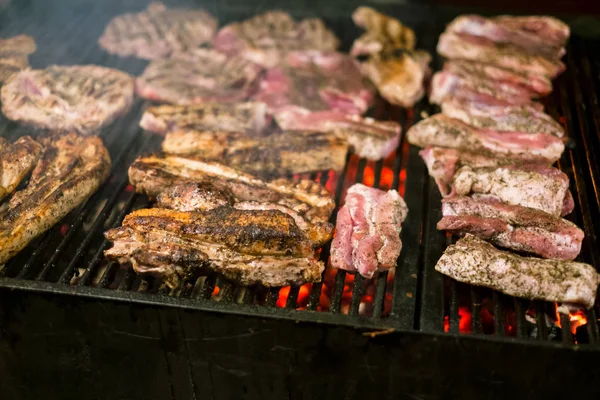 Saftig gebratenes Fleisch, das nachts über den Kohlen auf dem Grill gegrillt wird — Stockfoto