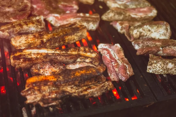 Saftig gebratenes Fleisch, das nachts über den Kohlen auf dem Grill gegrillt wird — Stockfoto