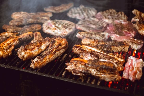 Gebratenes saftiges Fleisch, das über den Kohlen auf dem Grill gekocht wird — Stockfoto