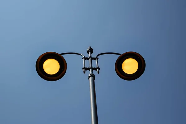 Yellow lighting street poles on blue sky — Stock Photo, Image