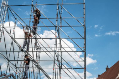 İnşaat işçileri iskele üzerinde çalışıyor.