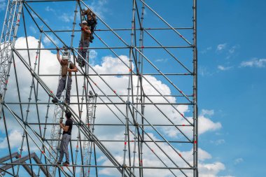 İnşaat işçileri iskele üzerinde çalışıyor.