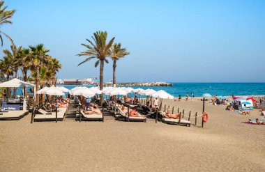 Mediterr kıyısında palmiye ağaçları ile plajda insanlar