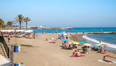 Mediterr kıyısında palmiye ağaçları ile plajda insanlar