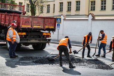İşçiler bozuk asfalt yolu onarıyor