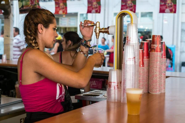 Uma mulher espanhola enche um copo de cerveja — Fotografia de Stock