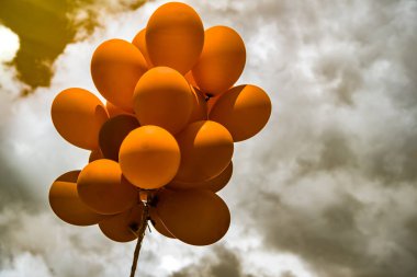 bulutlu gökyüzünde turuncu balonlar
