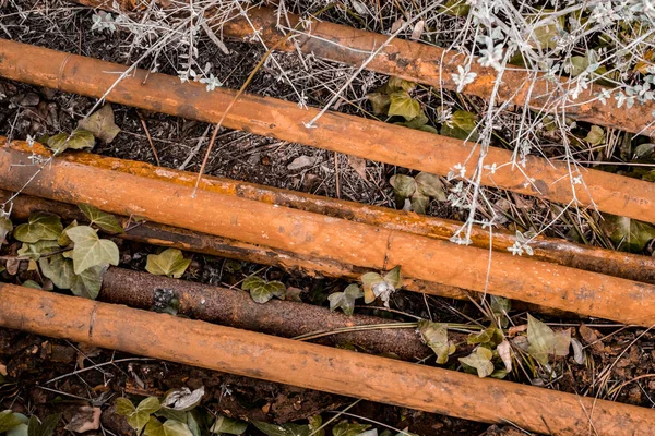 Rusty pipes thrown on the soil — Stock Photo, Image