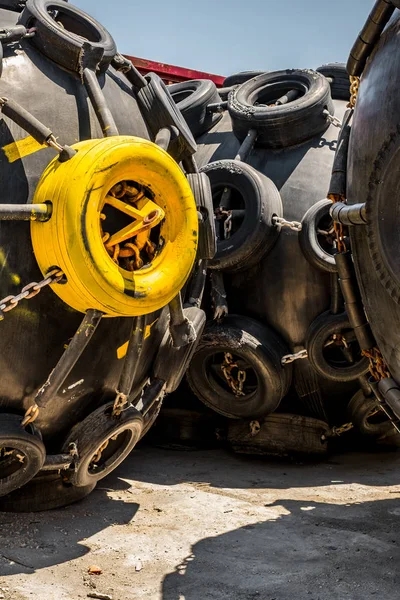 Um enorme pára-lamas de borracha pesado Marine Pneumatic cercado por pneus — Fotografia de Stock