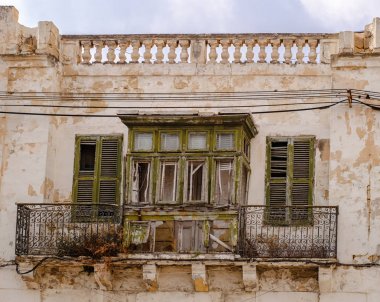 Geleneksel Malta evinde eski yıkık pencere ve balkon.