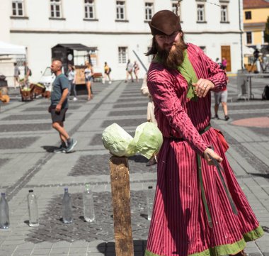 Ortaçağ şövalyesi kılığına girmiş bir adam kılıcıyla lahana keser.