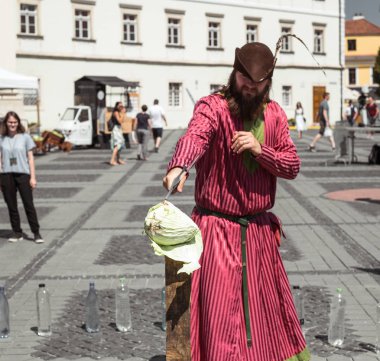 Ortaçağ şövalyesi kılığına girmiş bir adam kılıcıyla lahana keser.