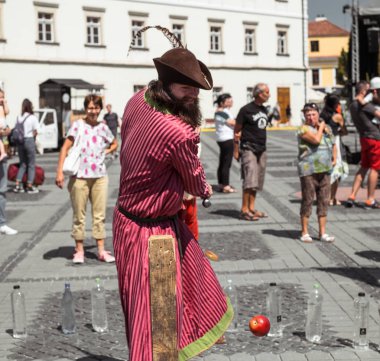 bir ortaçağ şövalyesi gibi giyinmiş bir adam ile farklı bir nesne keser