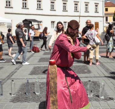 bir ortaçağ şövalyesi gibi giyinmiş bir adam ile farklı bir nesne keser