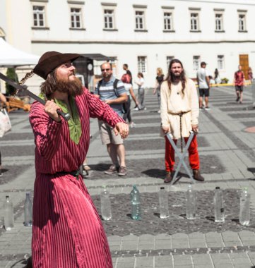 bir ortaçağ şövalyesi gibi giyinmiş bir adam ile farklı bir nesne keser