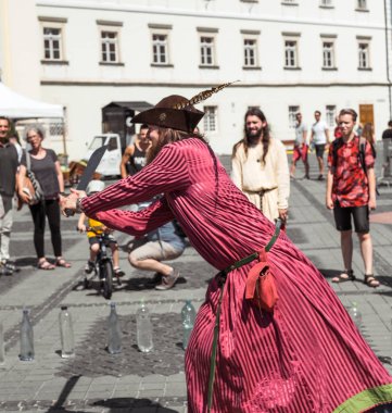 bir ortaçağ şövalyesi gibi giyinmiş bir adam ile farklı bir nesne keser