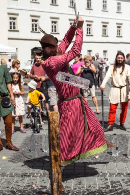 bir ortaçağ şövalyesi gibi giyinmiş bir adam h ile su şişesi keser