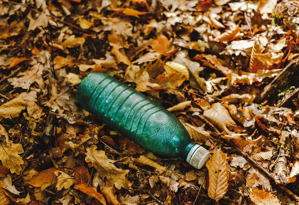 Egy zöld műanyag palackot dobott az erdőbe — Stock Fotó