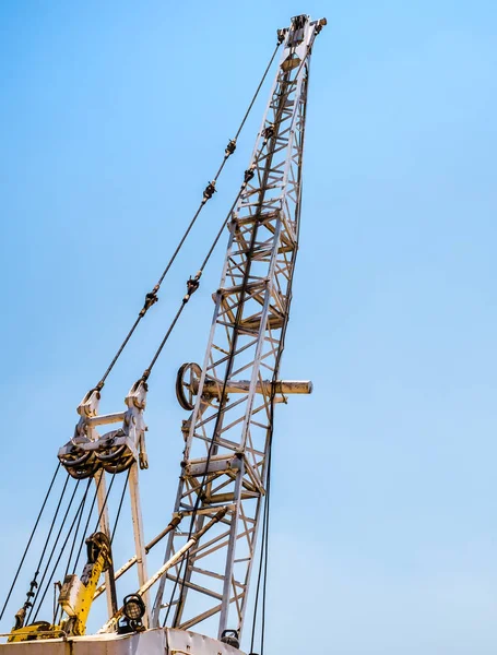 industrial white rusty crane on blue sky