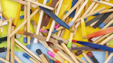 matchsticks of various shapes and colors with multicolored paper sticky notes on background