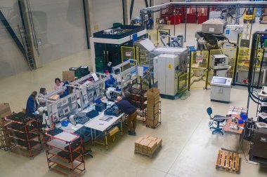 Sibiu City, Romania - 08 March 2021. Group of workers working on the production auto components line in factory, aerial view