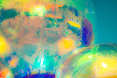 Canlı, soyut bir sanat eseri. Parlak, parlak bir yüzeye yakın çekim. Renkli bir ışığı yansıtıyor. Baskın renkler kırmızı, turuncu, sarı ve pembedir..