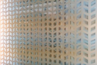 Geometrik desenli cam bir yüzeyin yakın görüntüsü, desen, senli, dokuma benzeri bir ızgarada düzenlenmiş, tekrar eden elmas ya da paralel kenarlı şekillerden oluşur.