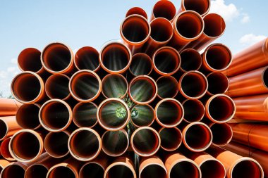 Polivinil klorürden yapılmış bir yığın turuncu boru.