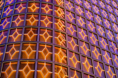 Her biri bir iç geometrik tasarım içeren sayısız kare panelden oluşan bir duvarın yakın görüntüsü