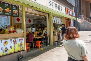 Chongqing, China - May 01 2025. Walking through a mega city with skyscrapers and charming historic buildings, in a vibrant tapestry of cultures, The streets are alive with a mix of locals and tourists