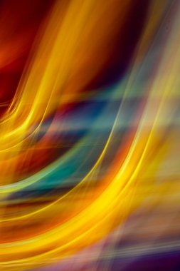 Canlı, üst üste binen sarı ve turuncu ışık yollarının oluşturduğu, koyu, bulanık bir arkaplan üzerinde kıvrımlı çizgiler oluşturan dijital soyut bir sanat eseri..