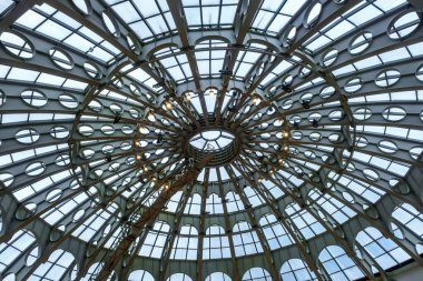 a grand, dome-shaped glass ceiling with an intricate metal framework.  Small, decorative light fixtures are interspersed throughout the structure.