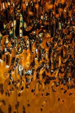 Soyut, son derece yansıtıcı ve metalik yüzey. Karmaşık, akışkan desenleri var. Yüzey dinamik ve canlı bir görsel etki yaratıyor. Pürüzsüz, parlak bir dokusu var, sıvı metale benziyor.