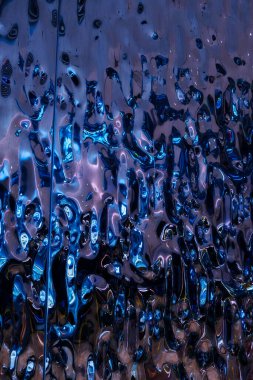 Soyut, son derece yansıtıcı ve metalik yüzey. Karmaşık, akışkan desenleri var. Yüzey dinamik ve canlı bir görsel etki yaratıyor. Pürüzsüz, parlak bir dokusu var, sıvı metale benziyor.