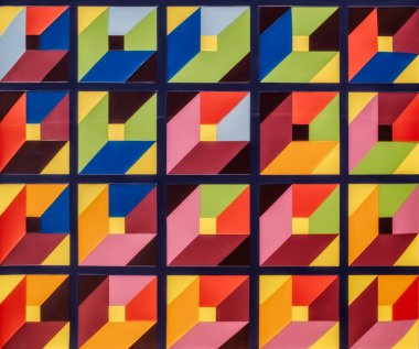 Birbirine kenetlenmiş üçgenlerin tekrarlayan bir kalıbını içeren geometrik mozaik çizimler, ızgara benzeri bir yapıda düzenlenmiştir. Mozaik fayanslar göz alıcı ve canlı bir görsel etki yaratıyor.