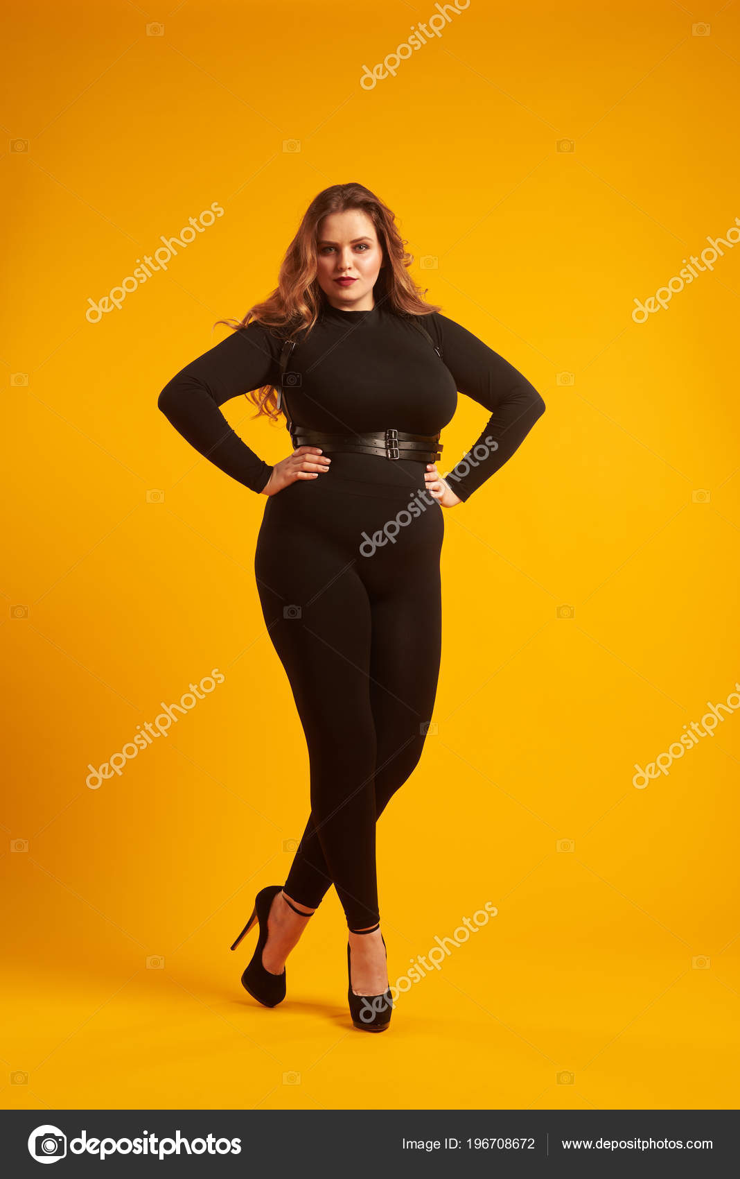 Beautiful curvy girl in sexy clothes posing at studio Stock Photo