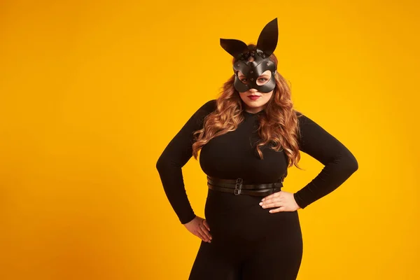 Сексуальная уверенная модель в кожаной маске кролика, держащаяся за руки на бедрах — стоковое фото