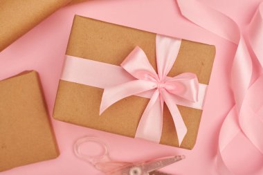 Pembe saten kurdele ve pembe flatlay üzerinde mevcut kutusunun yakınında bulunan makas