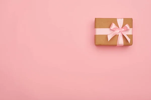 Cute present box with pink bow placed at the right corner — Stock Photo, Image